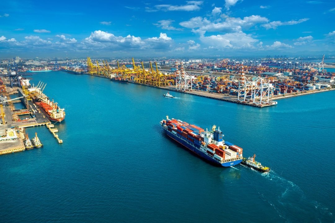 Vista aérea de puerto con buque de carga y contenedores